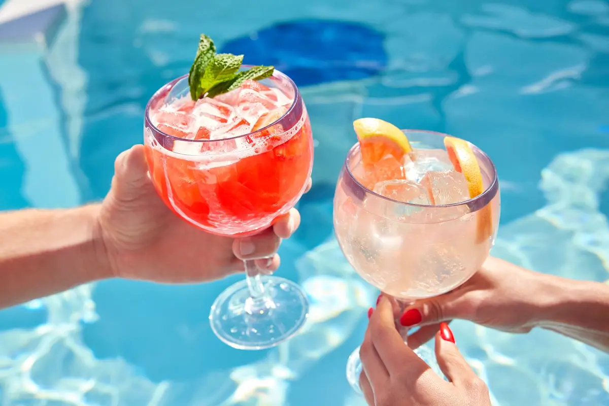 Poolside Cocktails - Two people enjoying refreshing cocktails by the pool